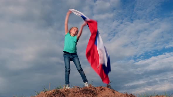 Blonde Girl Waving National Russia Flag Outdoors Over Blue Sky at Summer Russian Flag Country