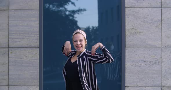 Young Girl Student Wears Stylish Headband and Striped Jacket Stands Alone Outdoors on Street Shouts