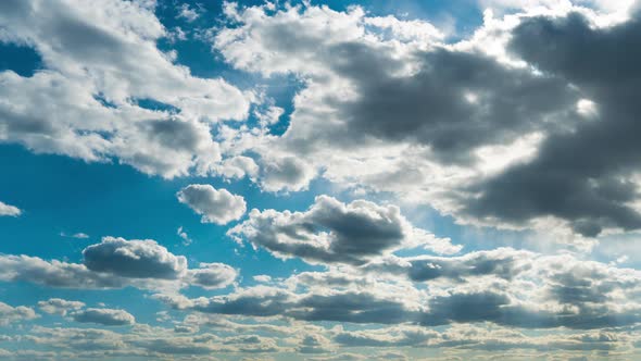 White Fluffy Clouds Slowly Float Through the Blue Daytime Sky Timelapse