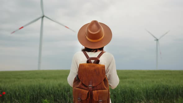 Young girl in the field against the background of windmills