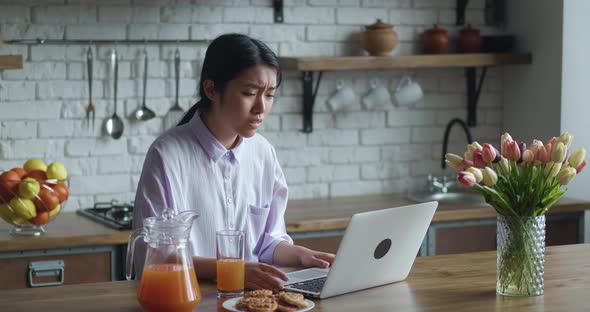 Frustrated Asian Woman Working Laptop at Home