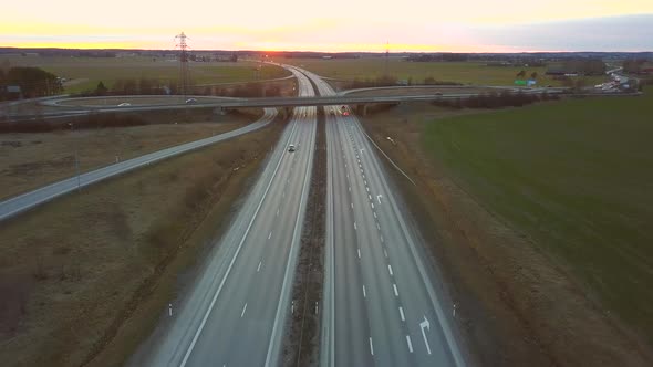 Aerial view of freeway intersection with moving traffic cars.