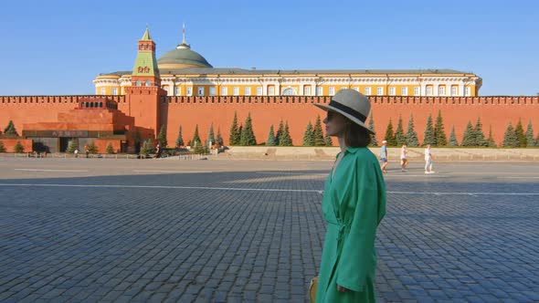 Beautiful girl in a green dress on an empty Red square