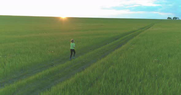 Sporty Child Runs Through a Green Wheat Field