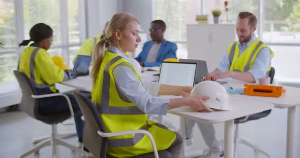 Beautiful Female Architect Looking at Camera and Leaving Workplace in Office