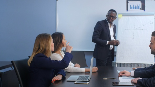 Colleagues asking a question to a businesswoman during