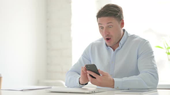 Successful Man Celebrating on Smartphone