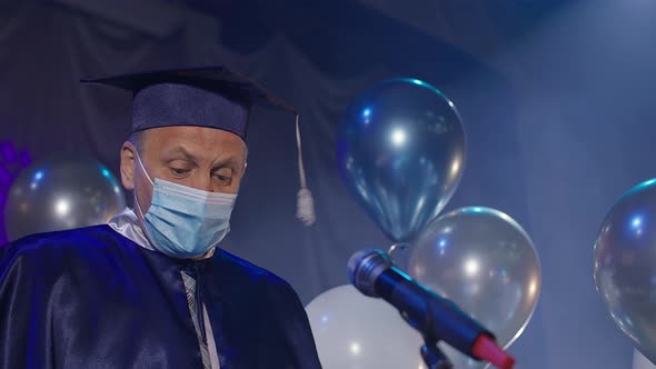 University Male Professor in Gown and Medical Mask are Solemnly Presenting Diplomas to Students