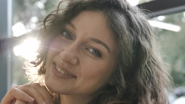 Lady with Light Makeup Smiles and Poses Looking Into Camera