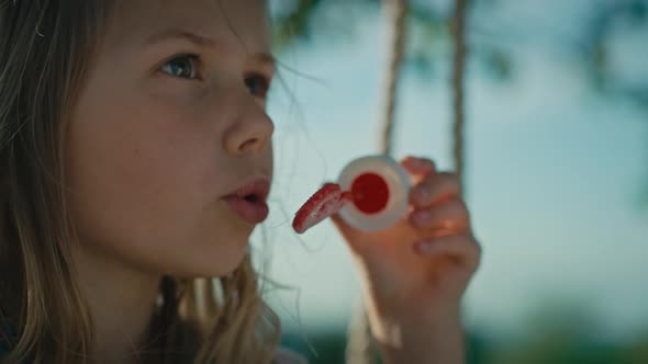 Close up of caucasian girl playing with bubbles and swinging. Shot with RED helium camera in 4K.