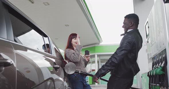 Man And Woman While Car Refueling Rejoice And Give Five One To Each Other