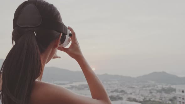 Woman Watching with Virtual Reality Device on Roof Top