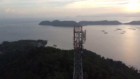 Telecommunication tower on sunset near sea