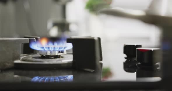 A Man's Hand Ignites a Gas Burner with Electric Ignition