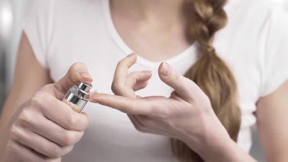 Woman Squeezes a Drop of Cream From the Bottle Dispenser To the Finger Tip, Face and Body Care