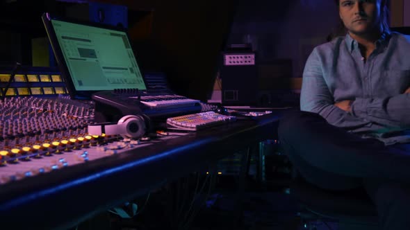 Male sound engineer sitting at a mixing desk