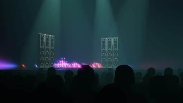 Silhouettes of a crowd of fans in front of empty stage or scene. Concert visuals