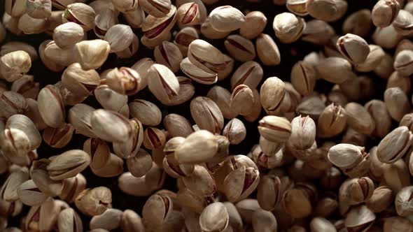 Super Slow Motion Shot of Pistachios Flies After Being Exploded Against Black Background 1000Fps