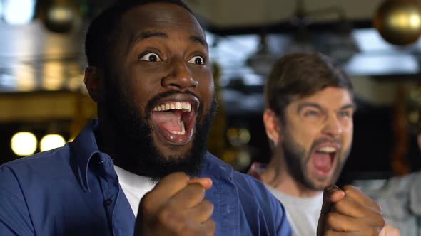 Multiethnic Men Cheering for Sports Team Winning Match, Celebrating Goal in Pub