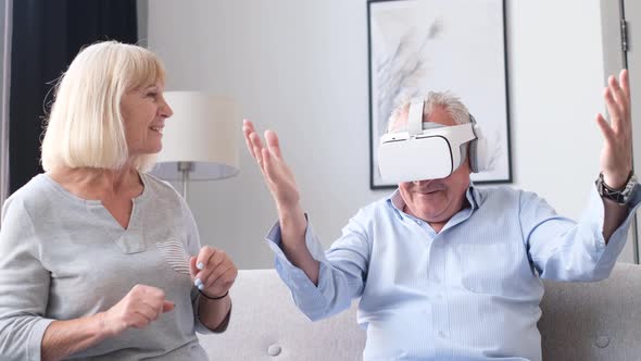 Retired Grandparents Having Fun Sitting on Sofa at Home They Use Virtual Reality Glasses