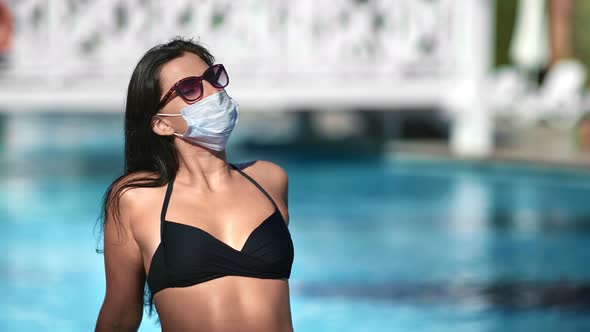 Woman Sunbathing Near Swimming Pool Wearing Protective Medical Mask