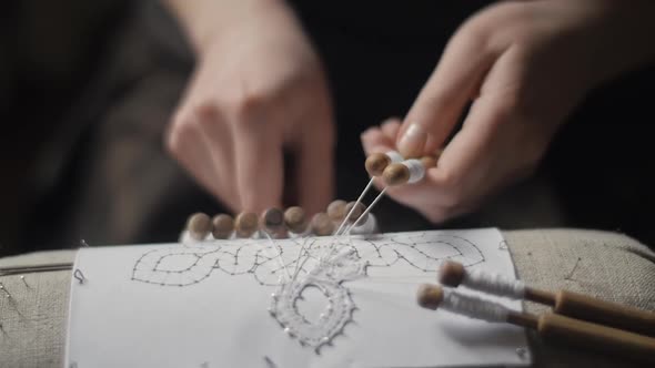 Closeup of Female Hands Weaving Lace with Bobbins