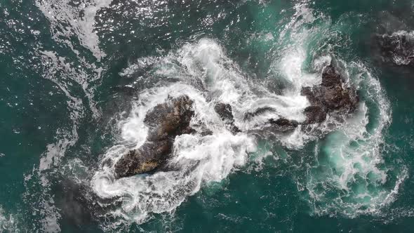 Top Down Aerial View of Giant Ocean Waves Crashing and Foaming