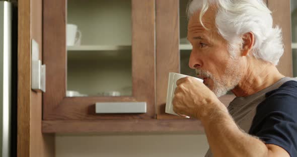 Senior man having coffee in kitchen 4k