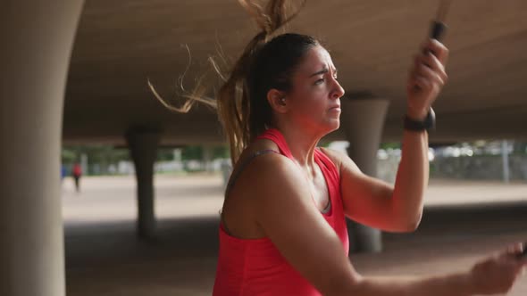 Caucasian woman working out under a bridge