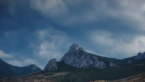 Timelapse of Swirling Clouds Flying Across the Blue Sky Over the Tops of the Mountains