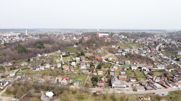 Town of Vilkija and majestic red brick church on hilltop, aerial view