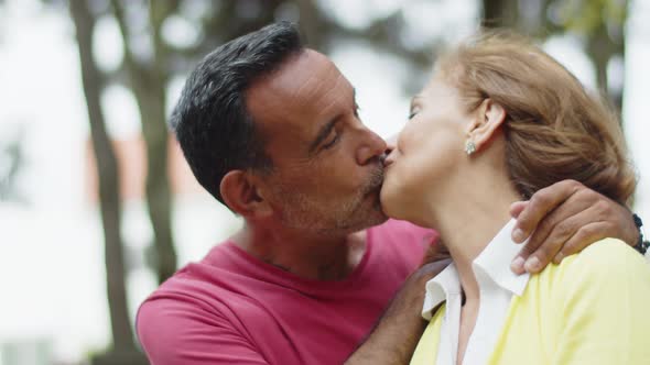 Closeup of Happy Senior Couple Hugging and Kissing in Park