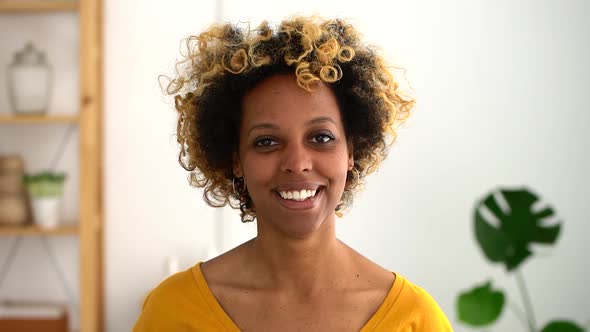 Headshot of African Woman Smiling Indoors Spbd. Female with Bleached Curly Hair Look at Camera