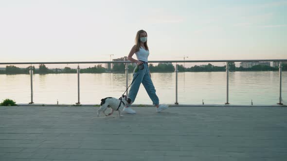 Woman Wearing White Face Mask Walking with Dog.