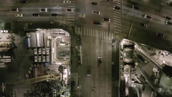 AERIAL: Overhead View on Intersection Street with Big Construction Site and Holes in Ground at Night