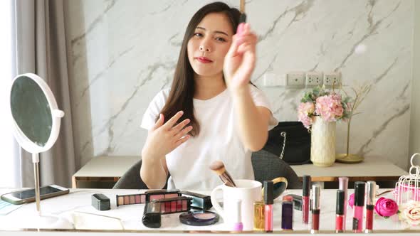 Portrait of young asian woman review cosmetics prosduct