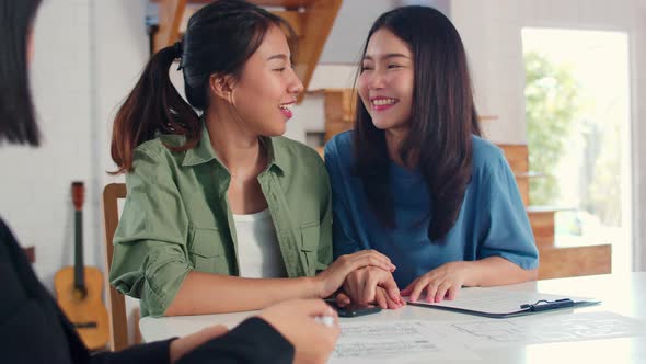 Asian Lesbian lgbtq women couple sign contract at home.