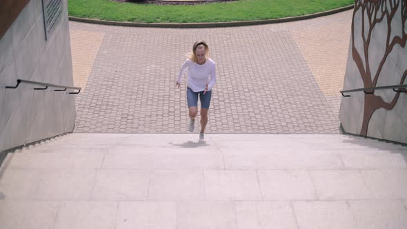 Woman Athlete Running Up Steps