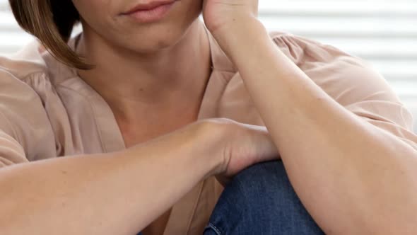 Close up of sad woman sitting on the floor