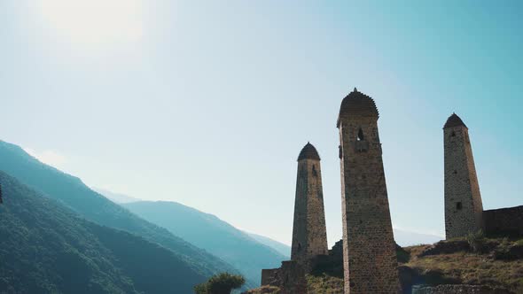 Old Stone Towers in Green Mountainous Terrain. Ancient Stone Buildings of Old Town Located on Green