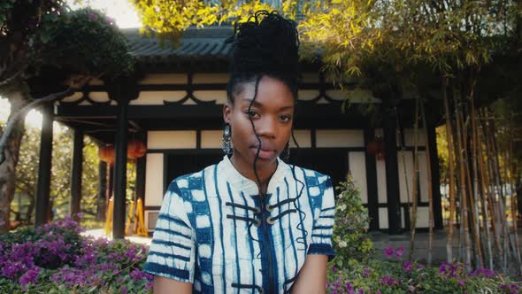 Stylish AfricanAmerican Woman in Fashionable Clothes Standing in Front of a Chinese Building
