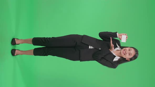 Full Body Of An Asian Business Woman With Smile Recommending A White Card On Green Screen