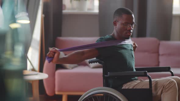 Black Man on Wheelchair Exercising with Resistance Band