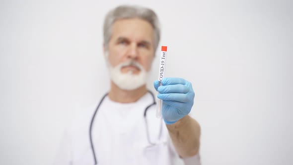 Adult Doctor Virologist Makes Cautionary Hand Gesture By Showing Test Tube with Samples of Virus