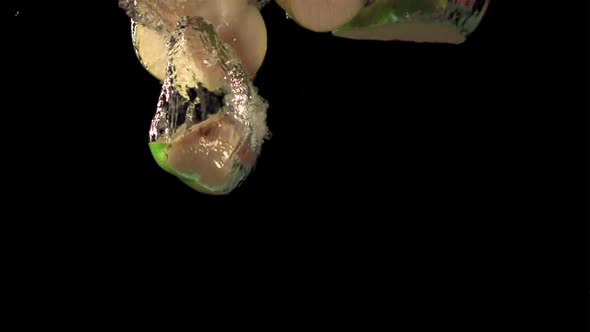Super Slow Motion Pieces of Ripe Pear Fall Under the Water with Air Bubbles