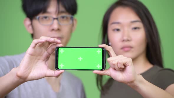 Young Asian Couple Showing Phone Together