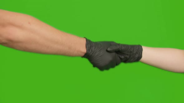 Handshake of man and woman in black rubber medical gloves, chromakey