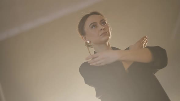 Angle View of Gorgeous Confident Adult Woman Moving in Slow Motion Rehearsing Dance in Fog