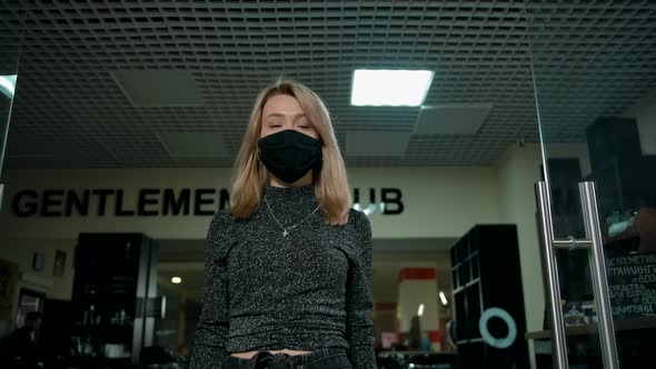 Beautiful Woman Barber in Protective Mask Walking Inside of Modern Barbershop