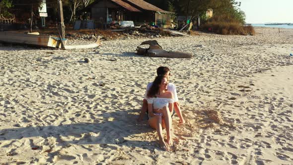 Boy and girl sunbathe on exotic seashore beach trip by shallow lagoon and white sandy background of 